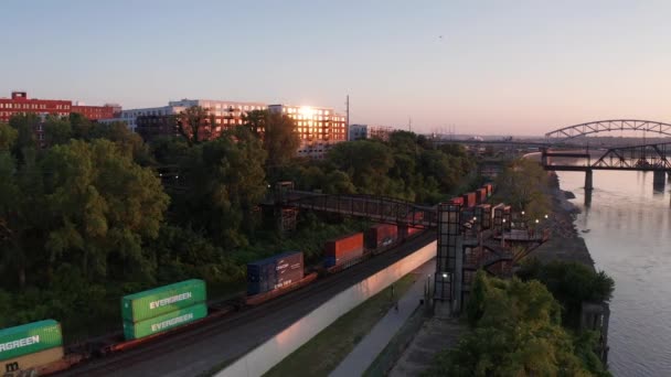 日落时分 在密苏里州堪萨斯城市中心 沿着密苏里河河岸的一列经过的货运列车的低空空中拍摄 — 图库视频影像