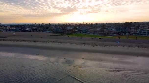 カリフォルニア州サンディエゴのオーシャンビーチの町で黄金の最初の光の日の出のアリアルショット マイルドカラーグレードは 主にインカメラ 本当にカラフルな日の出だった キノコだけだと思った — ストック動画