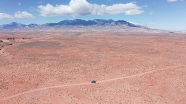 ユタ州の砂岩砂漠道路を走行する道路旅行で空中 キャンパーミニバン — ストック動画