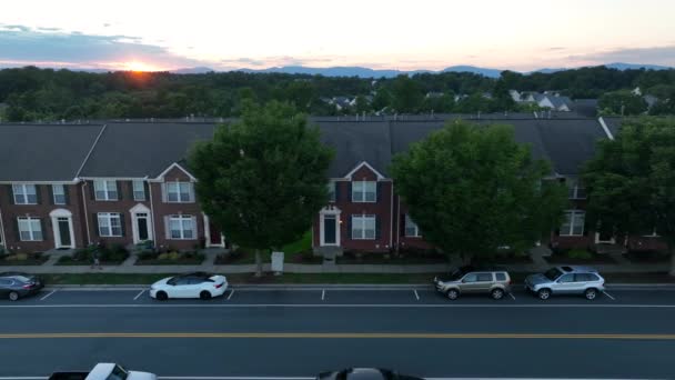 夜の静かな道路に沿ってアパートの建物 地平線の夕日 人は歩道を歩く アメリカにアメリカの住宅 — ストック動画
