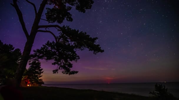 海の上の日の出の間に見えるオーロラと一緒に天の川銀河の星のタイムラプスショット — ストック動画