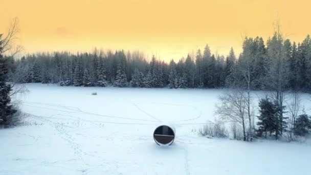 停在一座长方形小屋旁边的一辆汽车在空中向后移动 屋后环绕着雪树和结冰的湖面 — 图库视频影像