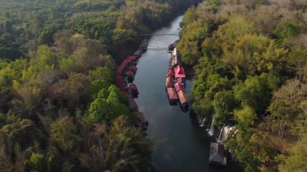 在泰国丛林中央的一条河流上 一架旋转的无人驾驶飞机拍了下来 瀑布和一个漂浮在河边的村庄 位于Kanchanaburi省Sai Yok — 图库视频影像