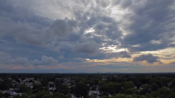 在纽约长岛的一个住宅区上空的空中时差 是在日落的阴天拍摄的 云彩飘过时 无人驾驶相机卡车就在树梢上 — 图库视频影像