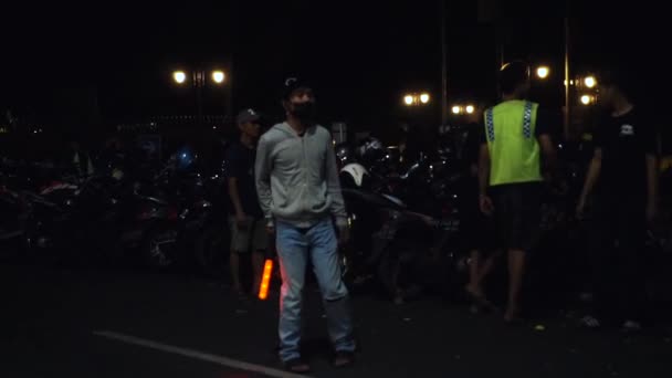 印度尼西亚马格朗 Magelang Indonesia 2022年7月29日 印尼警察身穿黄色背心 并在工作管理交通时吹口哨 夜市摩托车整整齐齐地停在路边 — 图库视频影像