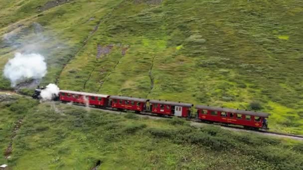 古い蒸気機関車がスイスの山の峠を越えて走っている 復元された蒸気機関車は オベルヴァルトからの古い歴史的なルートを運行しています — ストック動画