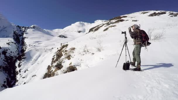 Фотограф Природы Дикой Природы Готовится Сфотографировать Зимний Пейзаж Заснеженных Горах — стоковое видео