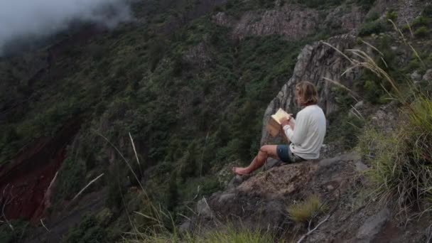 Uomo Artista Seduto Una Roccia Cima Una Montagna Capovolge Pagine — Video Stock