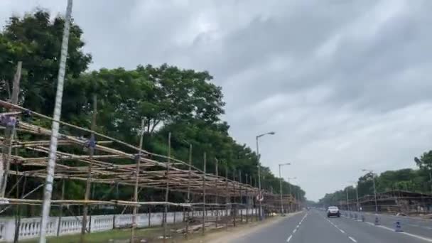 他のいくつかの車が他の車線を旅している間 車は旅団パレードグラウンドにつながる道路上の多くの竹の構造を通過しているとフラグが飛んでいます — ストック動画