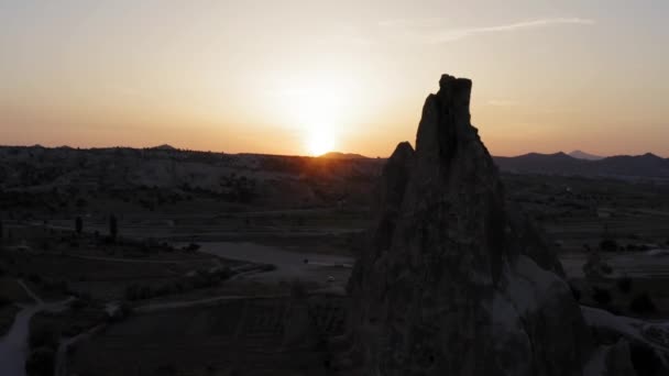 黄金の時間カッパドキア七面鳥の山の後ろに沈む太陽として妖精の煙突岩の形成の横に飛行ドローン — ストック動画