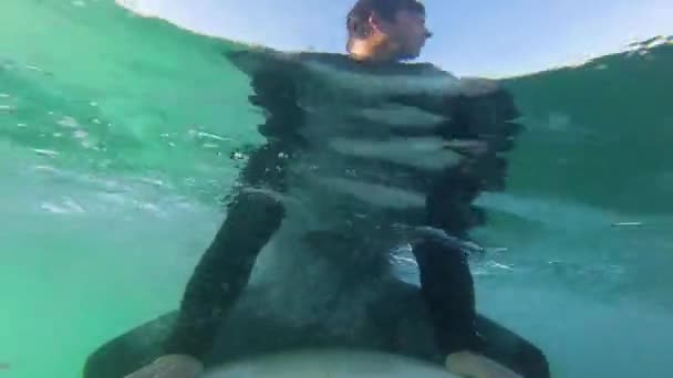 年轻冲浪男子的画像 日出时分在冲浪板上 身后有太阳 — 图库视频影像