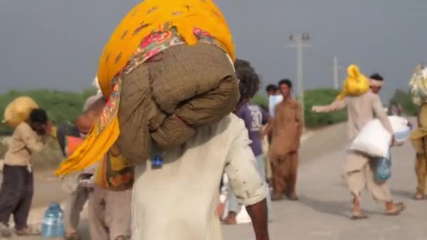 Pakistani Male Carrying Flood Relief Package Balochistan Walking Away Shoulder — Stock Video