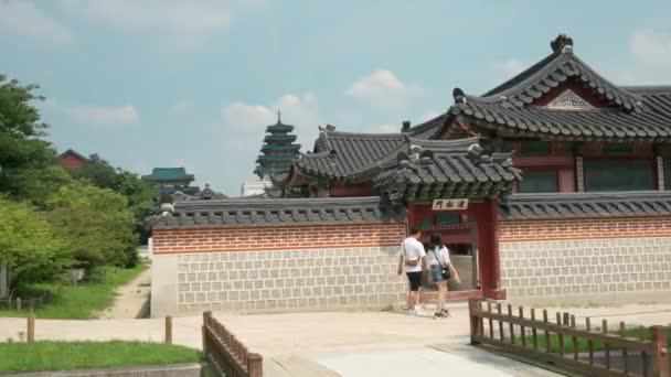 景福宮 キョンボックン 韓国のカップル旅行者が入力されますHamhwadang 韓国の伝統的な古いスタイルの王室の韓屋の建物 パンニングショット — ストック動画