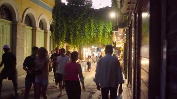 車のヘッドライトに照らされたアテネの狭い通りを歩く人々 — ストック動画