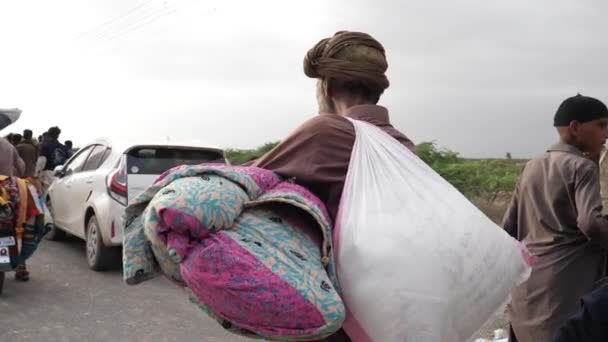 Pakistański Mężczyzna Chodzący Daleko Niosący Pakiet Pomocy Powodziowej Balochistanie Zwolniony — Wideo stockowe