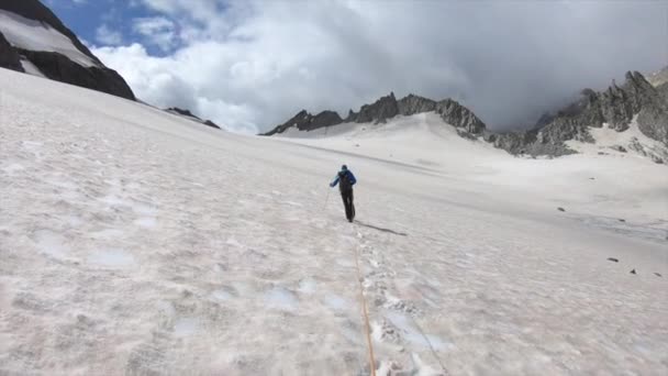 Montanhista Está Andando Uma Geleira Coberta Neve Lado Cumes Rochosos — Vídeo de Stock