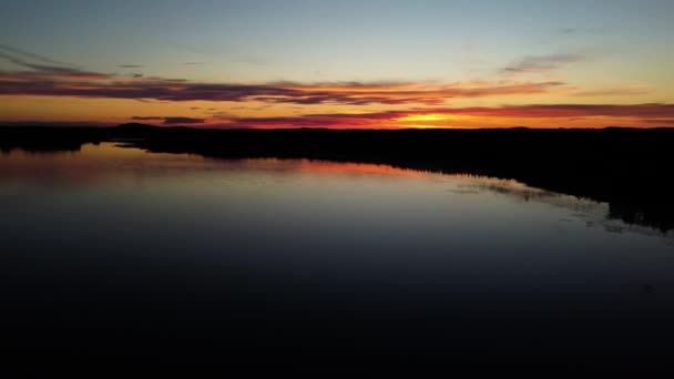 フィンランドのPieni Onkamo湖で行われたドローンショット 太陽は雲の上に赤とオレンジの輝きを放つ — ストック動画