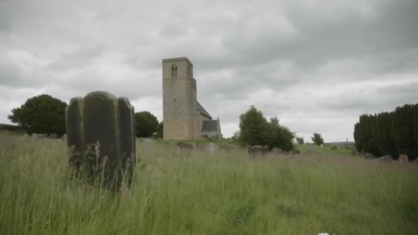 Ветер Дует Заросшему Кладбищу Показывая Древнюю Средневековую Церковь Заднем Плане — стоковое видео