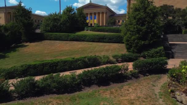阳光普照的费城艺术博物馆的低视角 摄像机在石像上打转 拍出美丽的风景和背景中的博物馆 — 图库视频影像