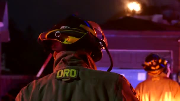 燃烧房屋的屋顶上可见的火苗 剧组正在努力控制住火势 — 图库视频影像