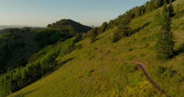 Flyg Över Backcountry Bergskedja Som Två Cyklister Cykla Ner Spår — Stockvideo