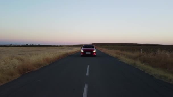 Kendaraan Merah Berkilau Berkendara Jalan Negara Saat Fajar Lampu Depan — Stok Video