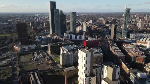 下の屋根とマンチェスター市内中心部の距離の高層ビルを示すオックスフォードロードからデアンゲートへの空中ドローン飛行 — ストック動画