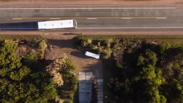 ウルグアイのエル チョロの住宅街の主要道路を横断するバス停で白いバスを降りる人の空中ドローン — ストック動画