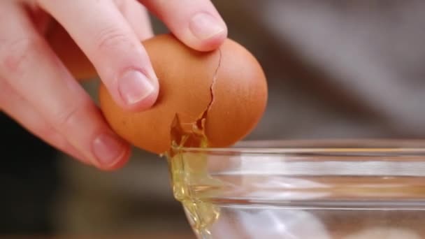 Коричневое Яйцо Трескается Бокам Прозрачной Чаши Смешивания Стекла Разрывается Части — стоковое видео