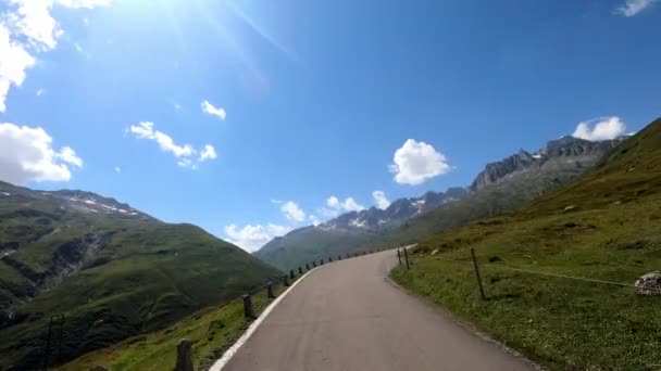 スイスのFurkapassの山道を運転する車のダッシュカムビュー 車は狭い道をスイスアルプスで運転しています — ストック動画