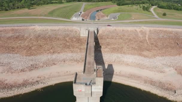 カンザス州を背景にワカルーサ川が流れるクリントン湖ダムのコントロールタワーの広い逆引き空中ショット — ストック動画