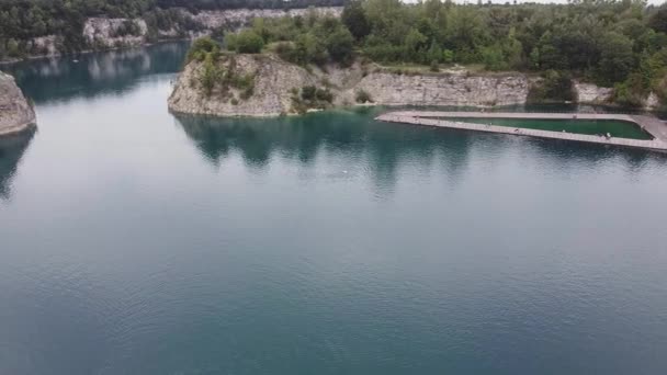 夏の日を楽しむ人々と一緒にポーランドのクラクフの湖や森の空中ビデオやトレーニングのために湖で泳ぐ男 — ストック動画