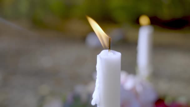白色的蜡烛在新坟墓的顶部燃着 关闭了慢镜头 — 图库视频影像