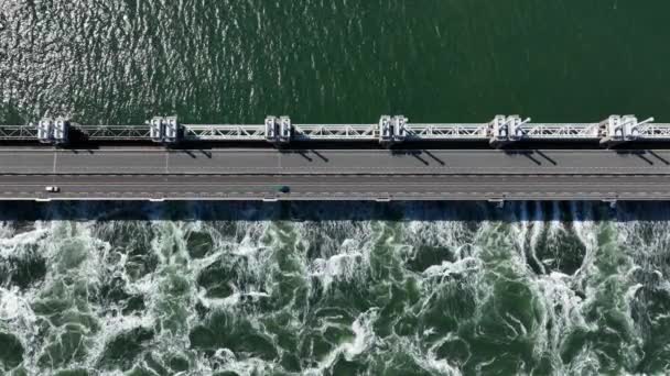 在阳光充足的日子里 在黑海地区德尔塔工程建设项目的泽兰大桥上驾驶汽车的空中自上而下镜头 防洪防暴增压屏障 — 图库视频影像