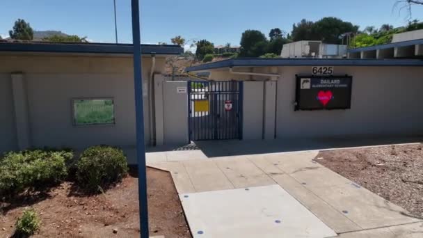 カリフォルニア州サンカルロス コミュニティの玄関ドアとコンクリートのサインの外のデイリー小学校教育機関の屋外ビルディングファサード — ストック動画