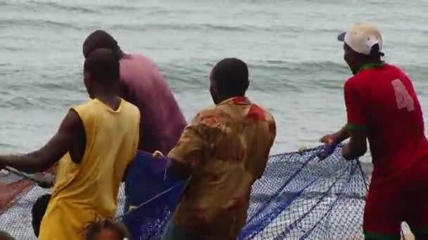 アフリカの4人の漁師が釣りの1日後にビーチで漁網を引く 閉じる — ストック動画