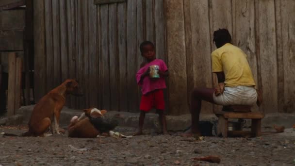 Afrikalı Bir Anne Evin Önündeki Tencereyi Karıştırıyor Bir Çocuğun Içtiği — Stok video
