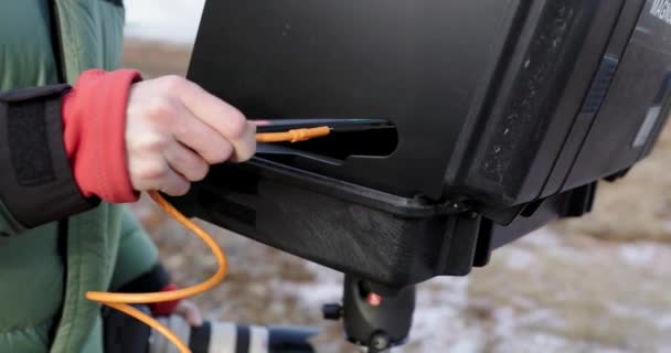 Venkovní Fotograf Zapojuje Oranžový Usb Kabel Notebooku Stojanu — Stock video