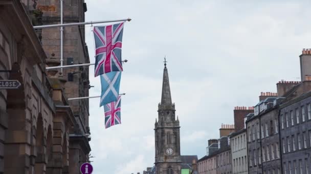 ファサードの旗竿にイギリスとスコットランドの旗 ロイヤルマイル エディンバラ — ストック動画