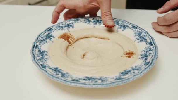 Chef Dekorera Hummus Platta Med Slipade Paprika Och Persilja — Stockvideo