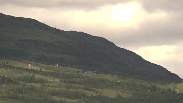 マークダーレン ノルウェーのRevhaugenからの夕方のタイムラプス 休暇の家と緑豊かな牧歌的な山の風景の上を高速で通過する雲と日光 日没前の夜の暖かい光 — ストック動画