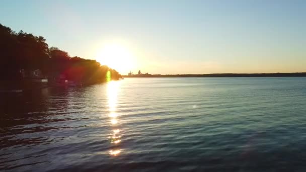 落日在爱德华王子县村镇的湖畔 无人机飞向水面 向着太阳飞去 湖畔有许多别墅 — 图库视频影像
