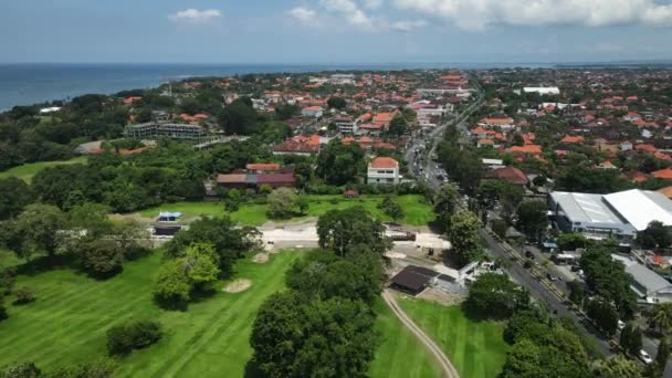 インドネシアのバリ島 サヌール 緑のフィールド バイパス道路交通とオーシャンホライズンの空中ビュー — ストック動画