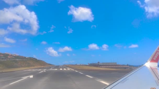 在一个阳光灿烂的日子里 一架在葡萄牙马德拉机场跑道上转弯的飞机的靠窗座位视图 — 图库视频影像