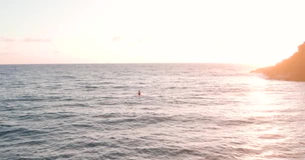 一个有决心的人驾驶着皮划艇 在金色的日出中迎着海浪划着桨 俯瞰着天空 — 图库视频影像