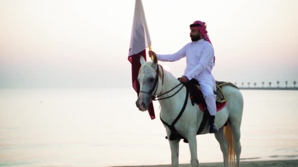 Cavaliere Cavallo Con Bandiera Del Qatar Vicino Mare — Video Stock