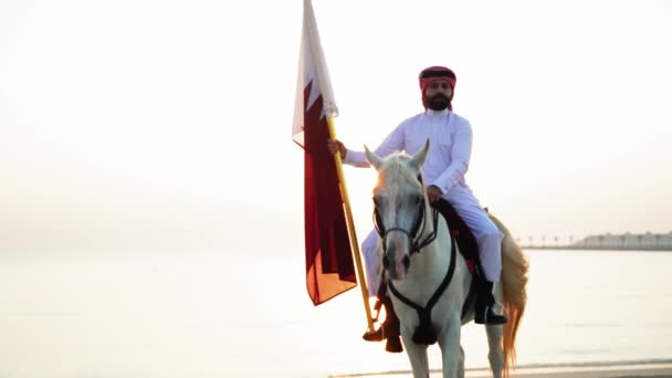 Cavaler Cal Ţinând Steagul Qatarului Lângă Mare — Videoclip de stoc