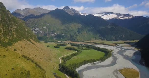 ニュージーランドのアルパイン地域の山の側面に暗い森に凍った川と広大な谷の上で右のパンニング — ストック動画