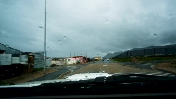在雨中驾车带着非正式住房穿过城镇 种族隔离概念 — 图库视频影像