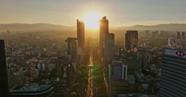 メキシコシティ航空V24逆フライバー 日没黄金の時間帯の高層ビルの間でパセオ レフォルマに輝く劇的な輝く太陽を捉えます マヴィックで撮影3 Cine 2021年12月 — ストック動画
